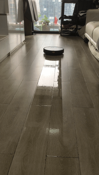 Persona relajada en un sofá mientras el robot limpia el suelo